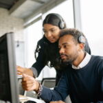 A Man and a Woman Pointing at the Computer Screen